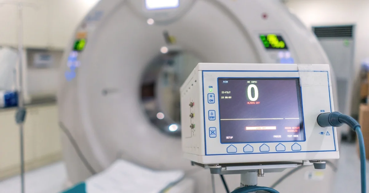 lose-up of a medical monitor in front of an MRI or CT scanner in a hospital room.